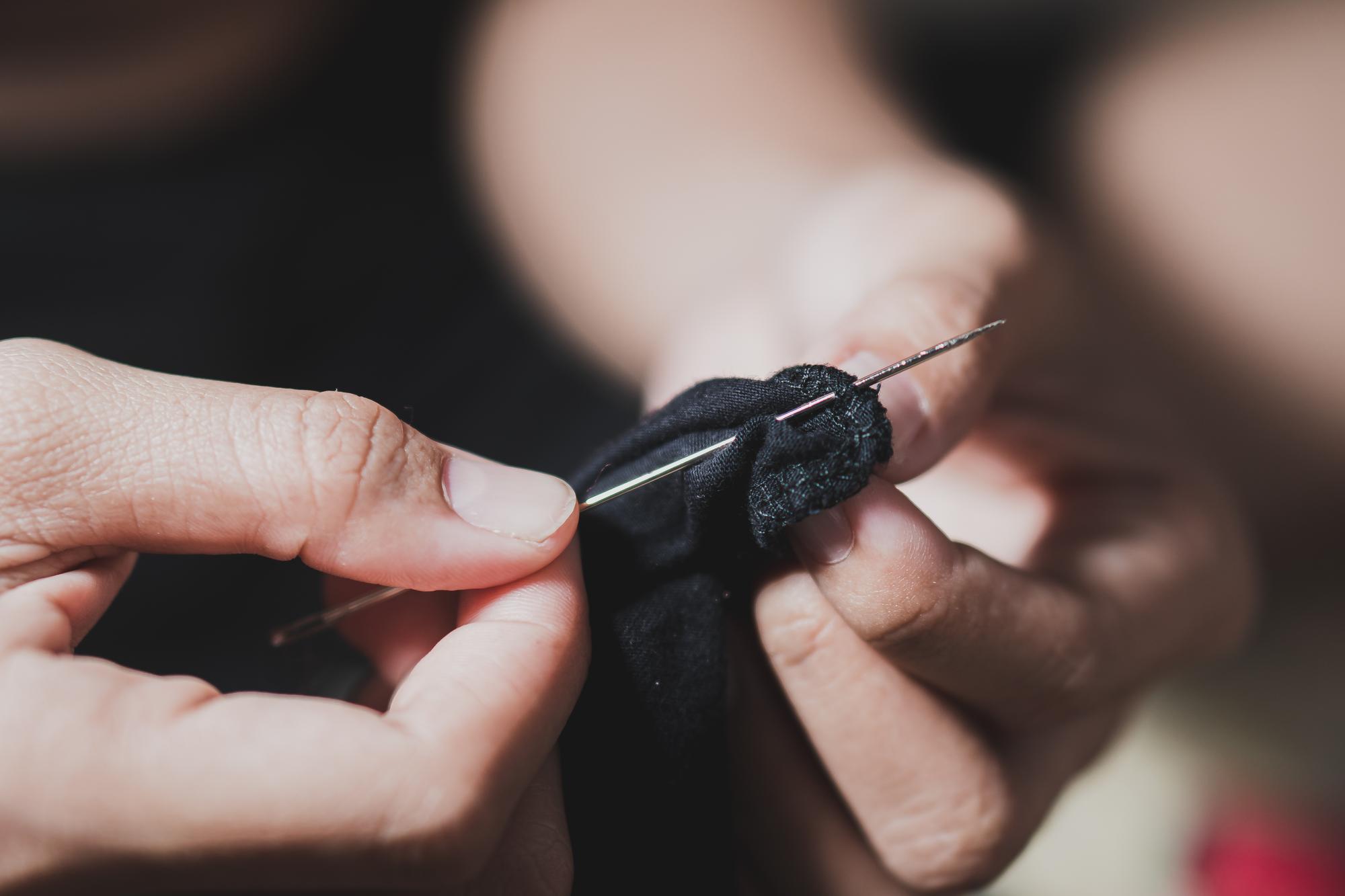 Artist in studio stitching textile